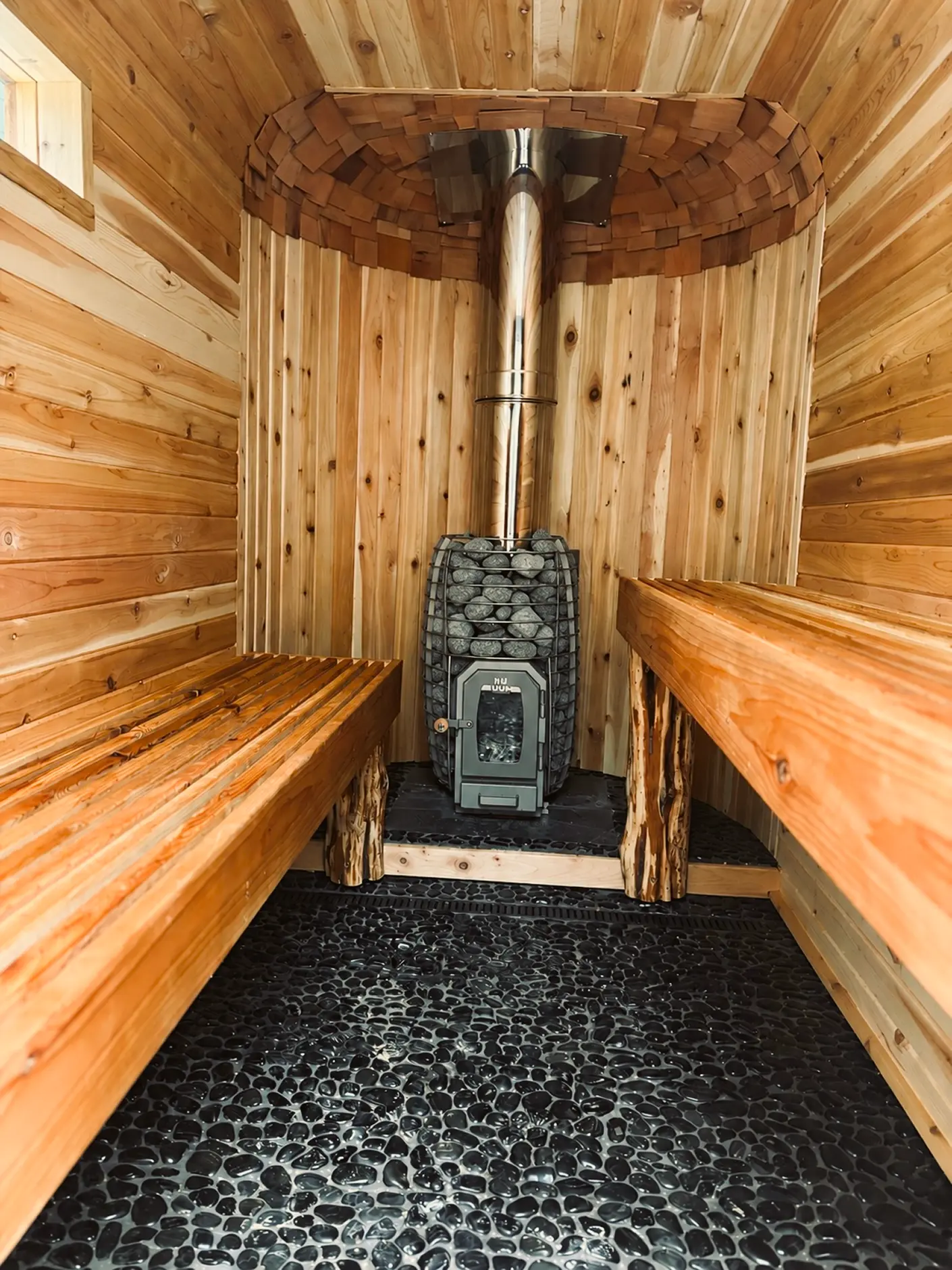 Cedar benches and stove inside the rental sauna